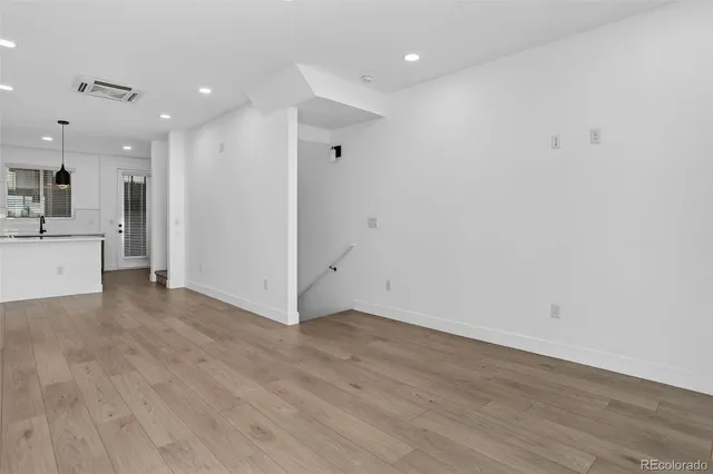 a view of an empty room with wooden floor