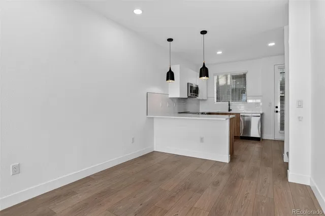 a view of a kitchen with a sink and wooden floor