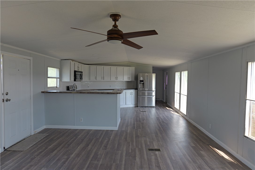 732 C Rogers Street Normangee, TX 77871 - Photo 2 of 10 a view of a kitchen and empty room with wooden floor and windows