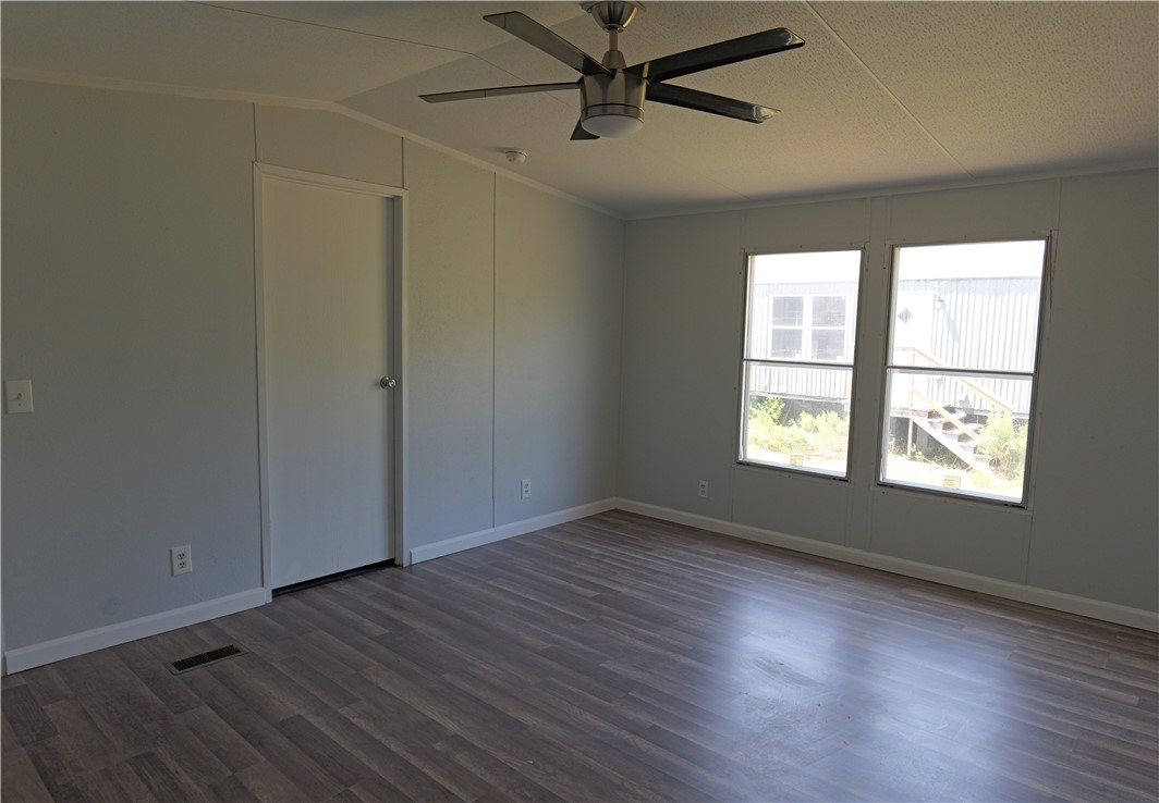 732 C Rogers Street Normangee, TX 77871 - Photo 6 of 10 an empty room with wooden floor fan and windows