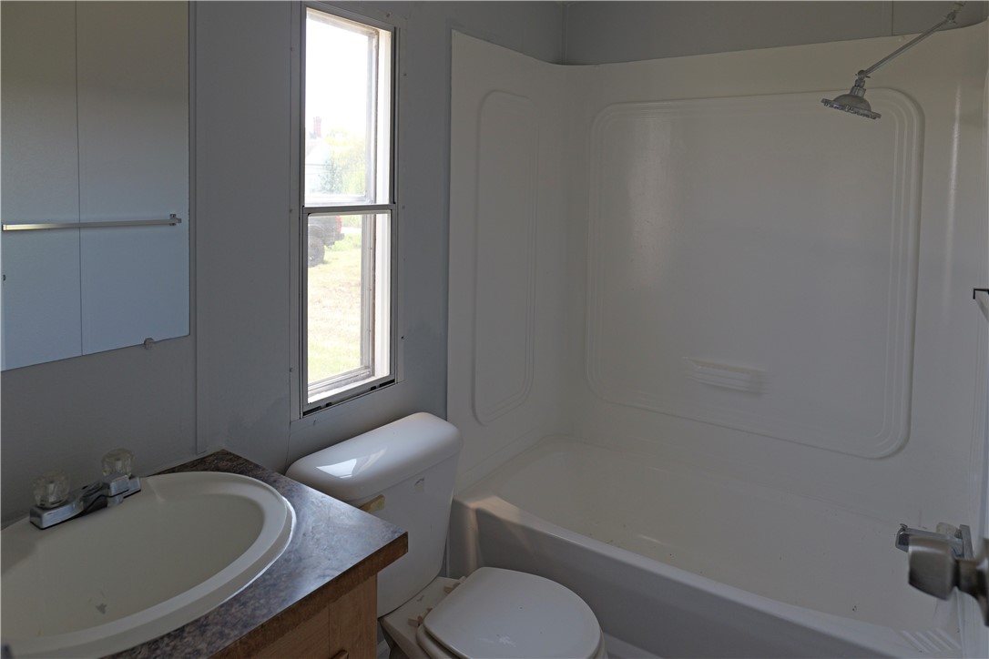 732 C Rogers Street Normangee, TX 77871 - Photo 10 of 10 a bathroom with a granite countertop toilet a sink and a window