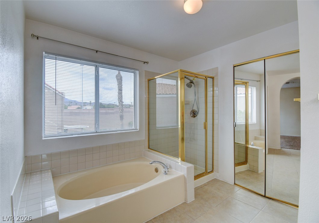 5 Tarryall Terrace Henderson, NV 89074 - Photo 38 of 44 Relax in this primary bathroom featuring a soaking tub, separate shower, and mirrored closet doors.