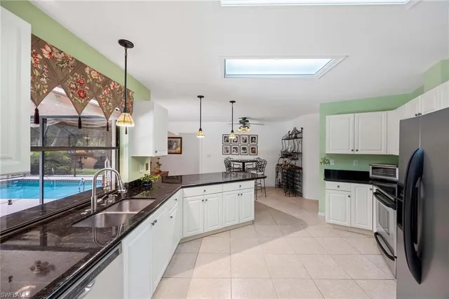 a large kitchen with a sink and stainless steel appliances