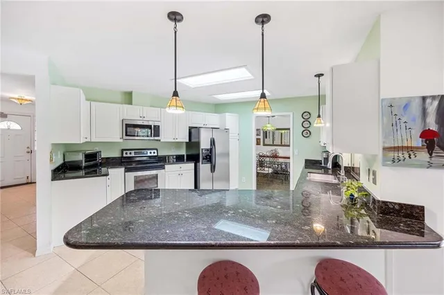 a kitchen with stainless steel appliances granite countertop a sink a stove and a wooden floors