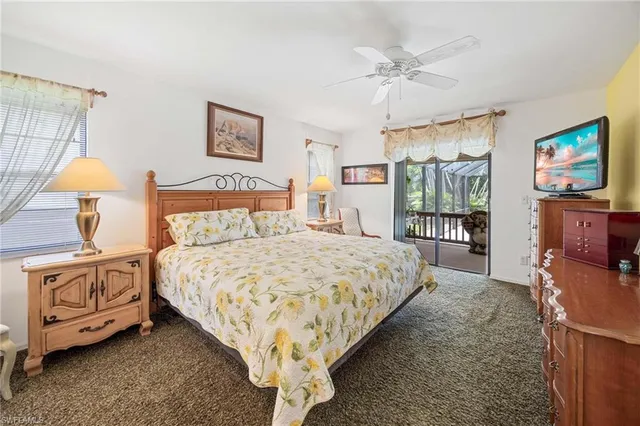 a bedroom with a bed and a flat tv screen on dresser