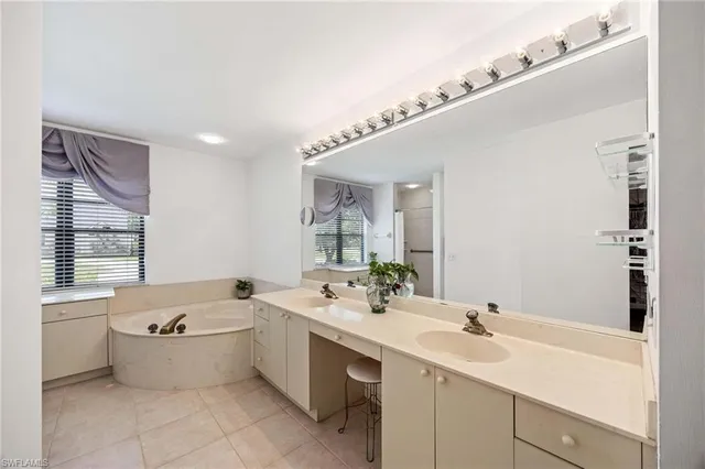 a bathroom with a double vanity sink mirror and bathtub