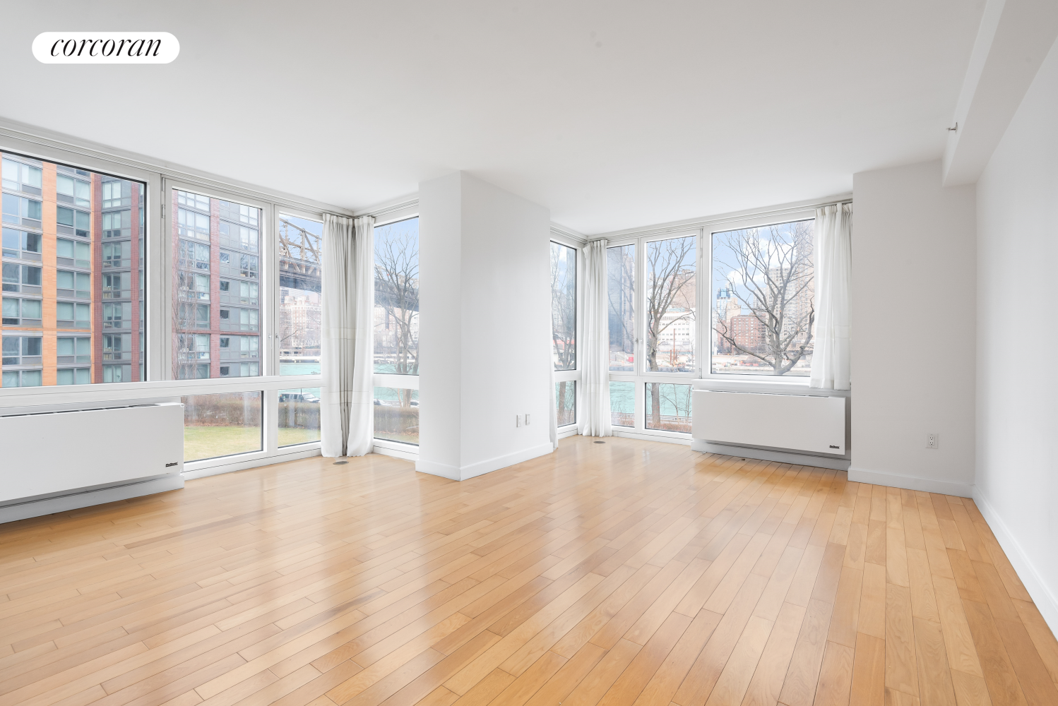 415 Main Street, Unit 2F Manhattan, NY 10044 - Photo 2 of 18 an empty room with wooden floor and windows