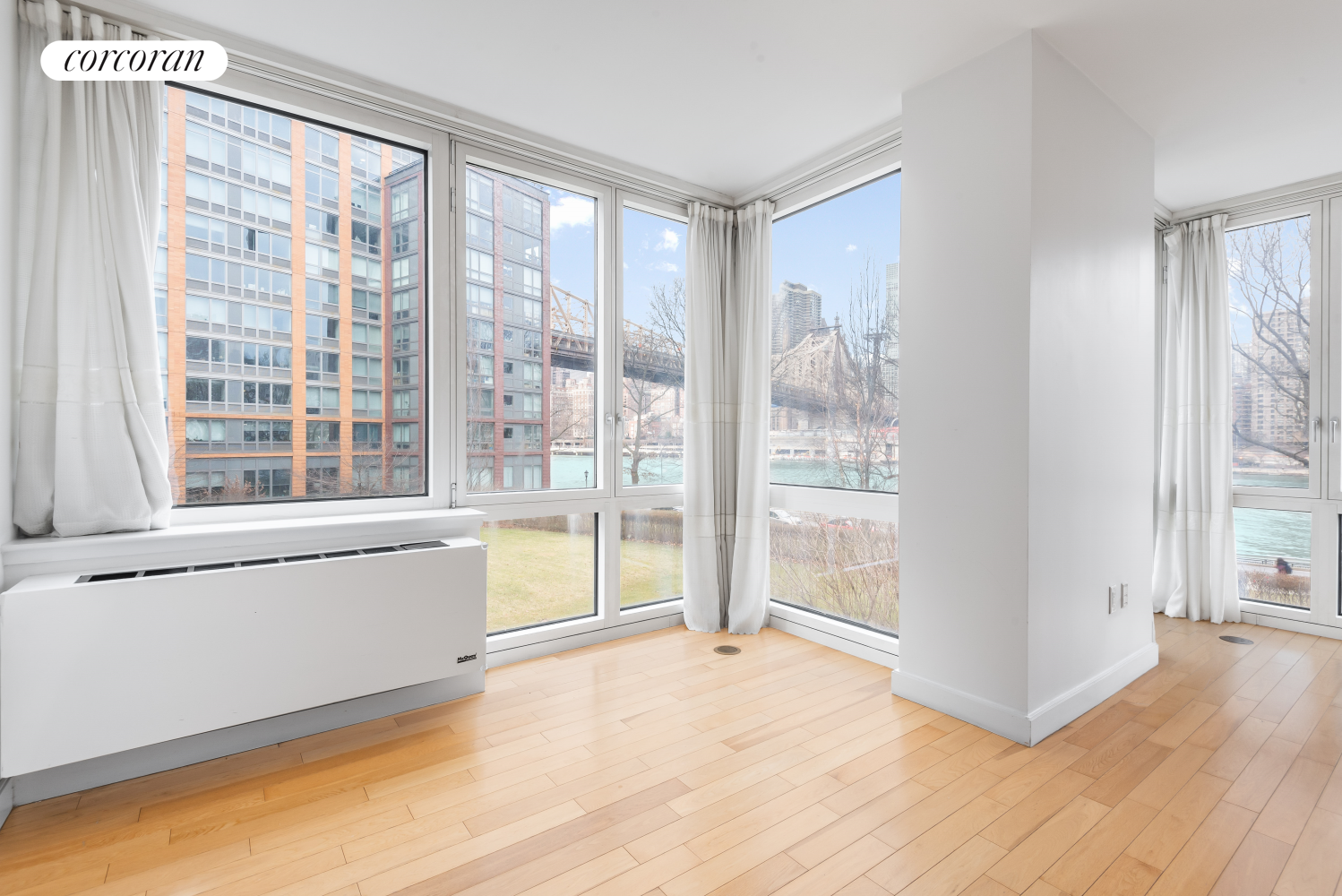 415 Main Street, Unit 2F Manhattan, NY 10044 - Photo 4 of 18 a view of an empty room with a window and wooden floor