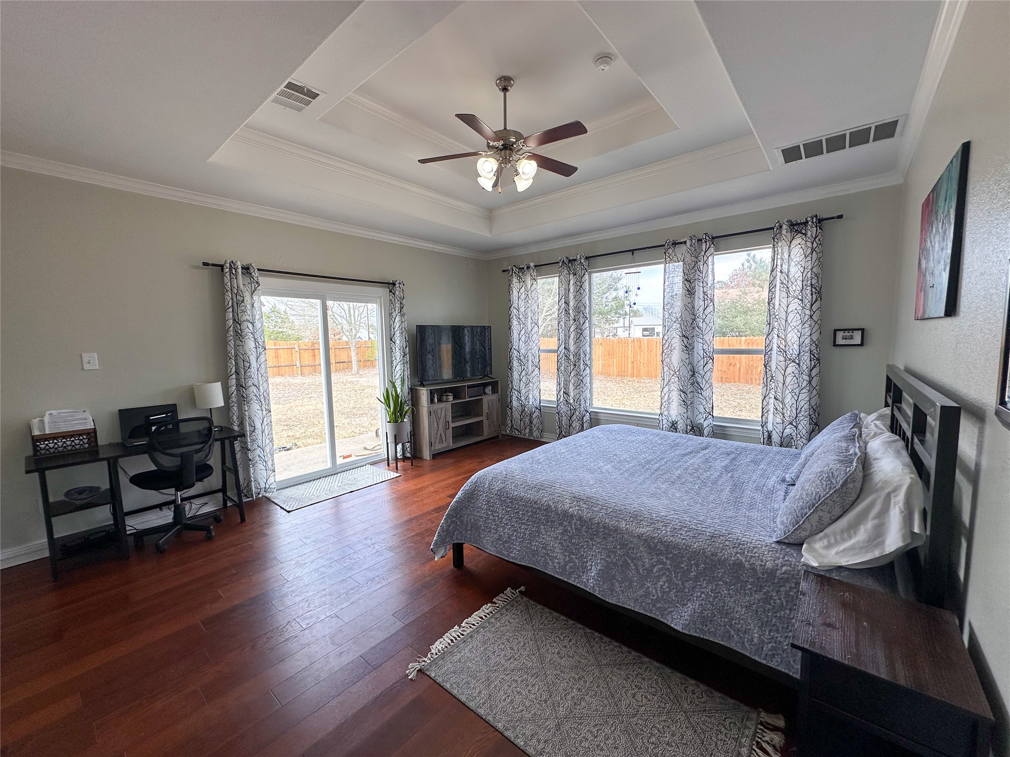 237 Cardinal Drive Paige, TX 78659 - Photo 12 of 37 Bedroom featuring access to outside, crown molding, hardwood / wood-style floors, ceiling fan, and a tray ceiling
