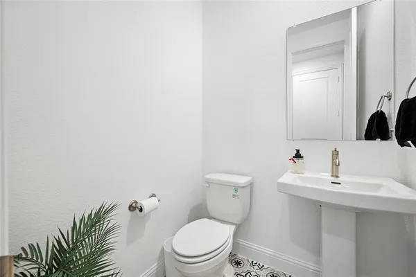 a bathroom with a toilet a sink and mirror