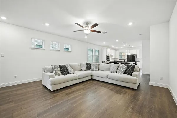 a living room with furniture and a wooden floor