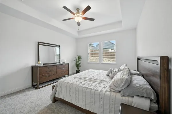 a bedroom with a bed dresser and window