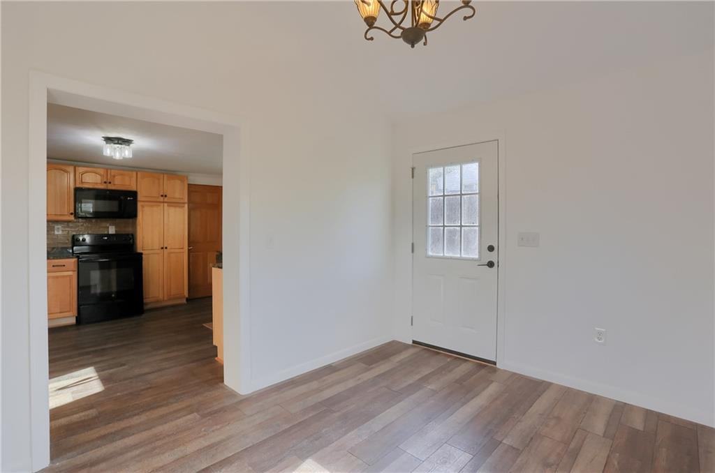 155 Dutchtown Road Butler, PA 16002 - Photo 8 of 34 an empty room with wooden floor and a kitchen
