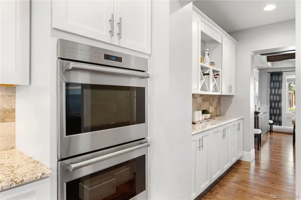 a kitchen with cabinets stainless steel appliances and wooden floor