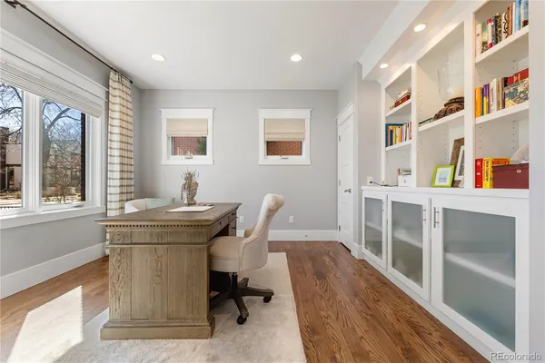 a view of a workspace with furniture and a window