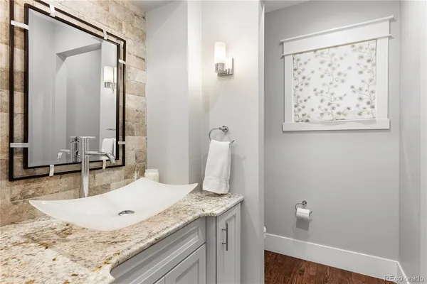 a bathroom with a granite countertop sink and a mirror