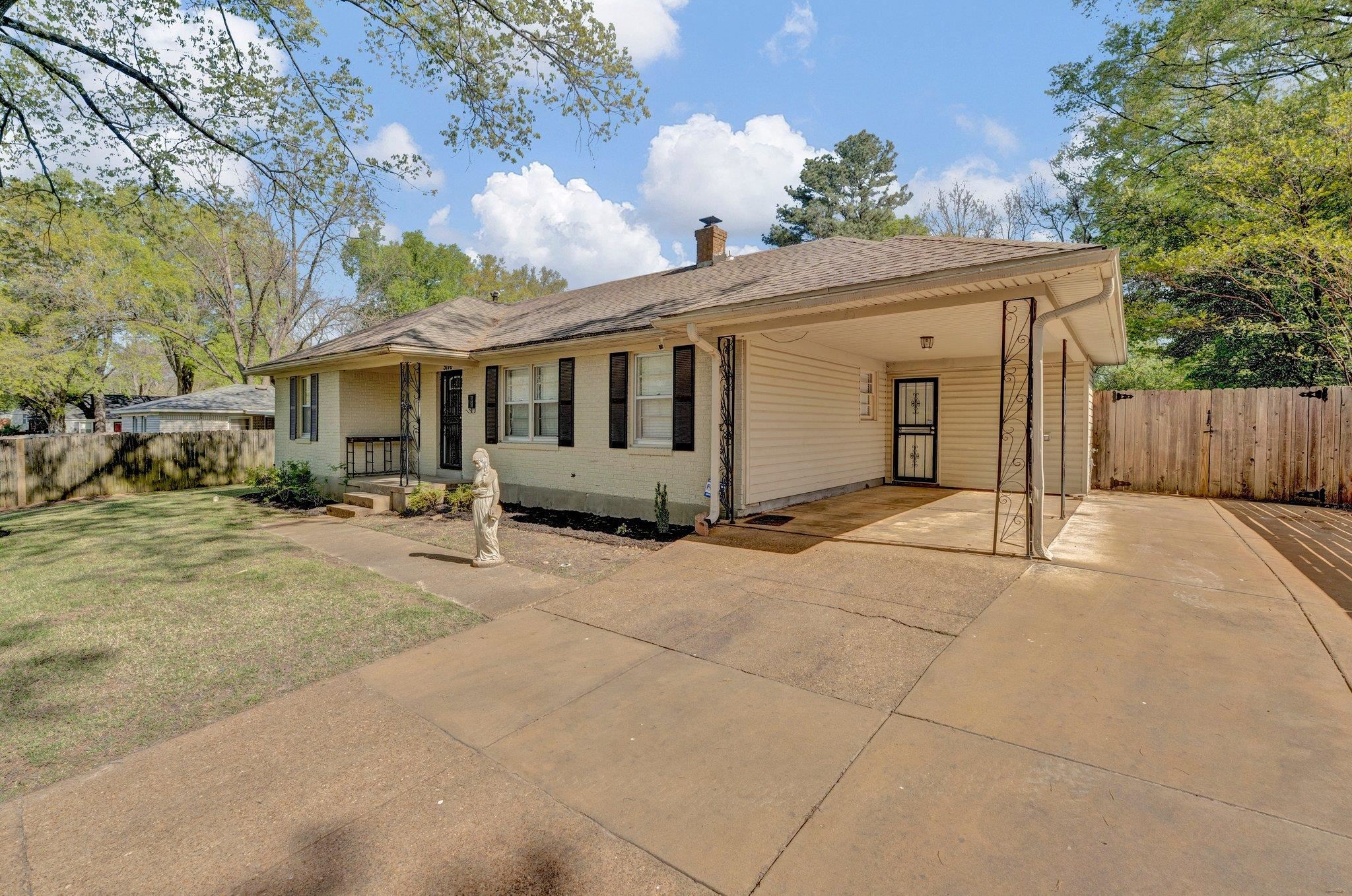 5176 Verne Road Memphis, TN 38117 - Photo 3 of 28 Ranch-style house featuring a carport, a front yard, fence, a chimney, and concrete driveway
