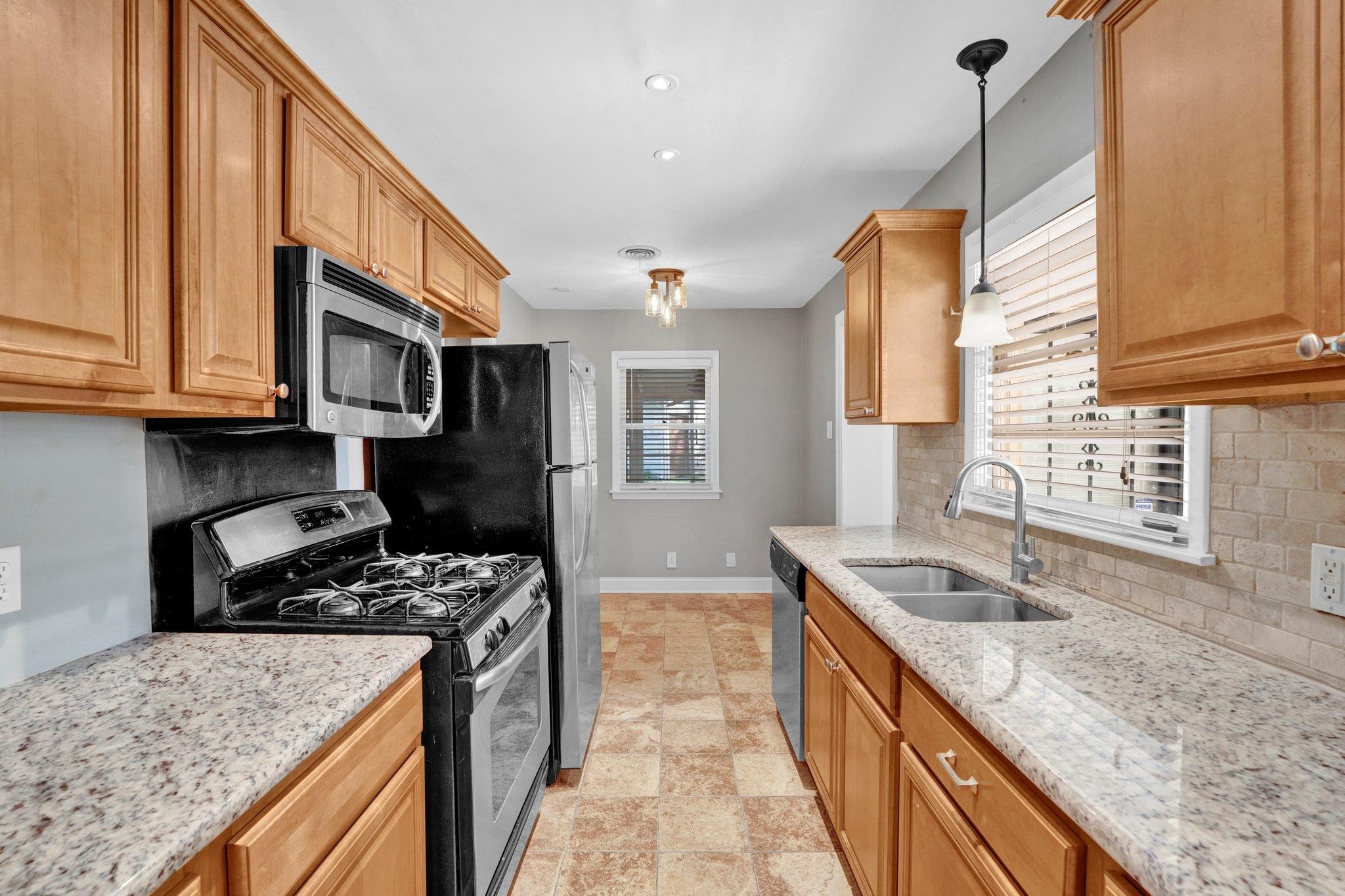5176 Verne Road Memphis, TN 38117 - Photo 9 of 28 Kitchen featuring a sink, backsplash, baseboards, and stainless steel appliances