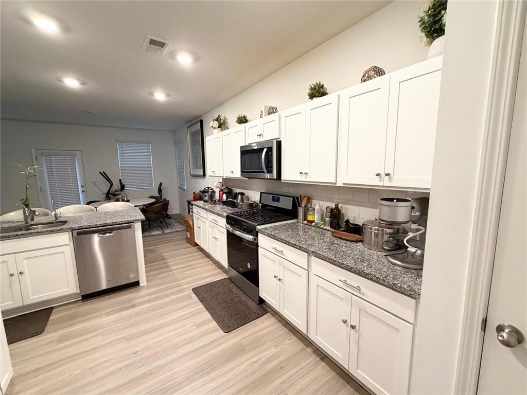 5790 Flint Lane Cumming, GA 30028 - Photo 8 of 40 a kitchen with granite countertop a stove top oven sink and cabinets