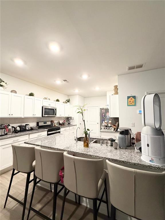 5790 Flint Lane Cumming, GA 30028 - Photo 9 of 40 a kitchen with stainless steel appliances granite countertop a sink a stove a refrigerator cabinets and chairs