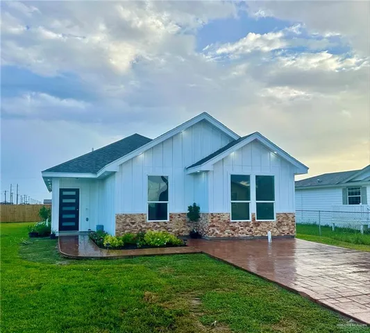 a backyard of a house with table and chairs with wooden fence