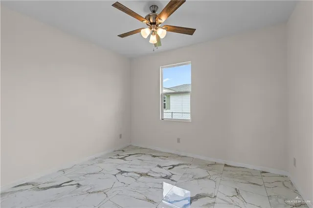 an empty room with a window and a fan