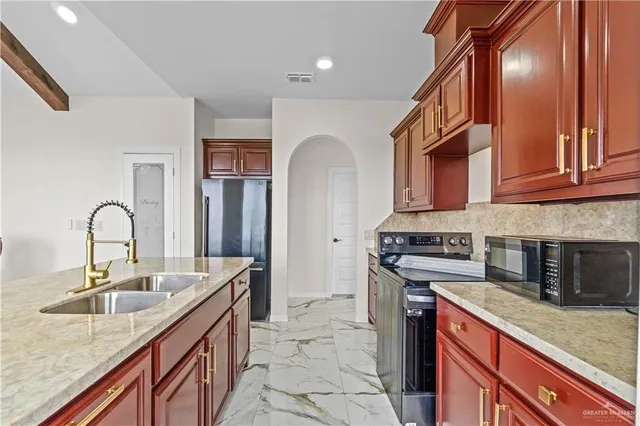 a kitchen with stainless steel appliances granite countertop a sink and cabinets