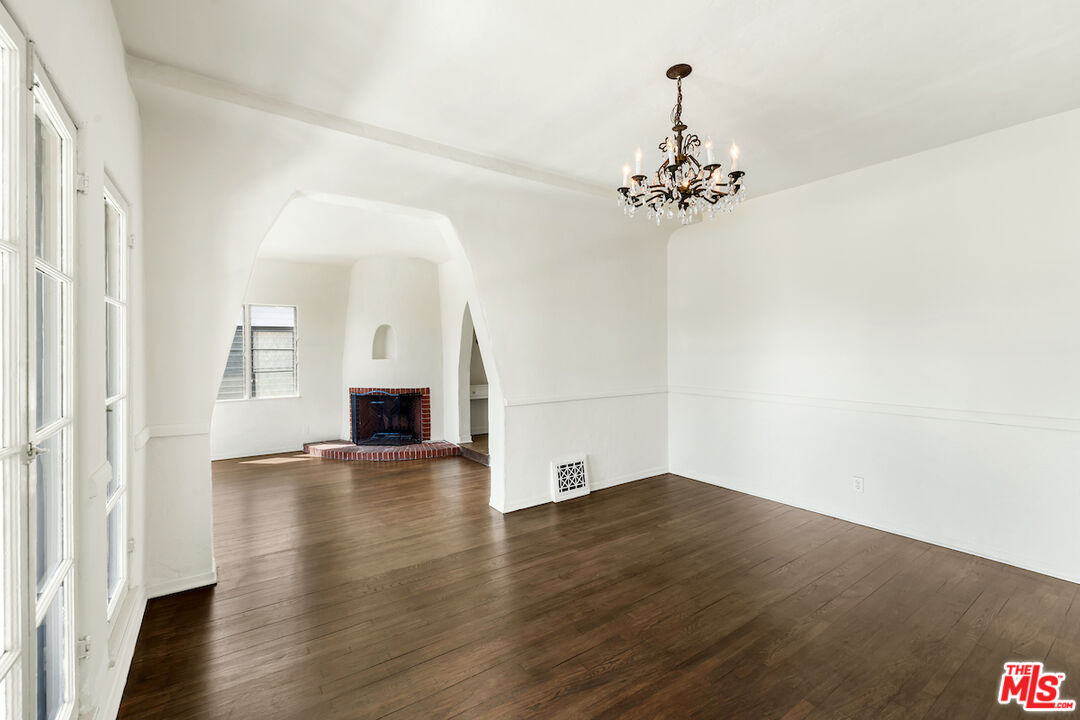 8221 West 4th Street Los Angeles, CA 90048 - Photo 11 of 21 an empty room with wooden floor and chandelier