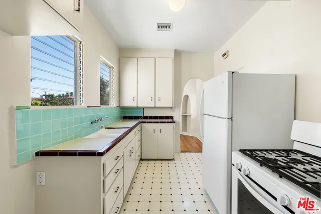 a kitchen with granite countertop a sink stove and refrigerator