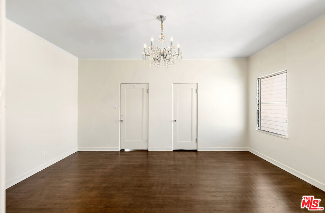 8221 West 4th Street Los Angeles, CA 90048 - Photo 16 of 21 an empty room with wooden floor chandelier and windows