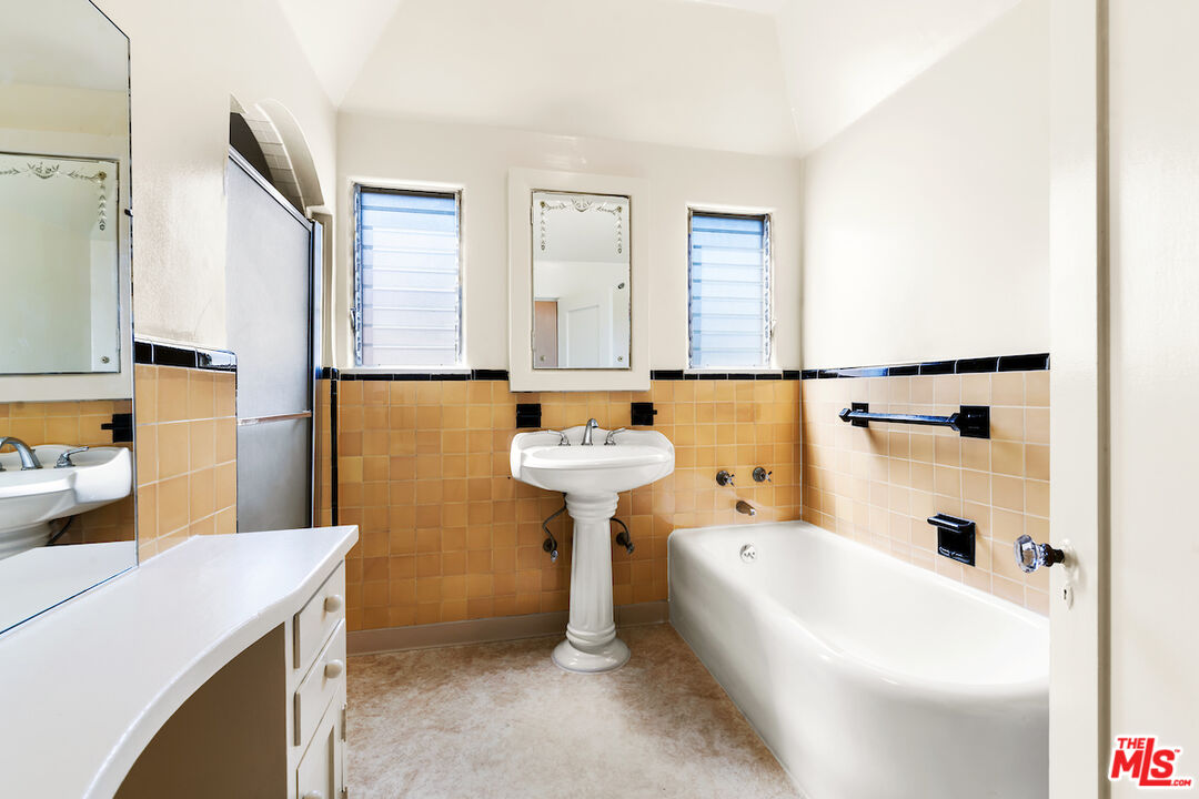 8221 West 4th Street Los Angeles, CA 90048 - Photo 19 of 21 a bathroom with a bathtub sink and mirror