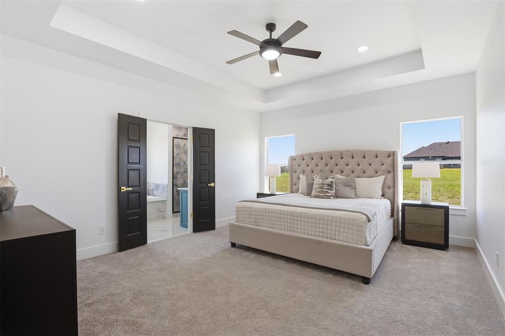 6657 Buffalo Ridge Circle Godley, TX 76044 - Photo 5 of 31 a spacious bedroom with a bed and a chandelier