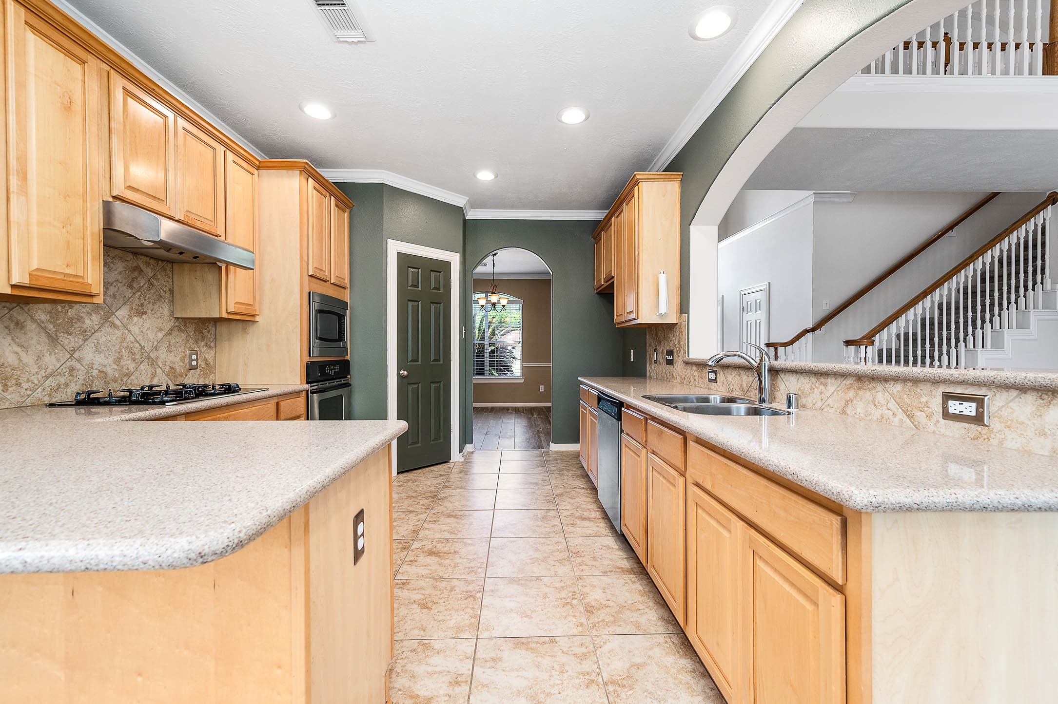 6411 Greencreek Meadows Lane Spring, TX 77379 - Photo 14 of 39 a large kitchen with kitchen island a large window a sink and stainless steel appliances