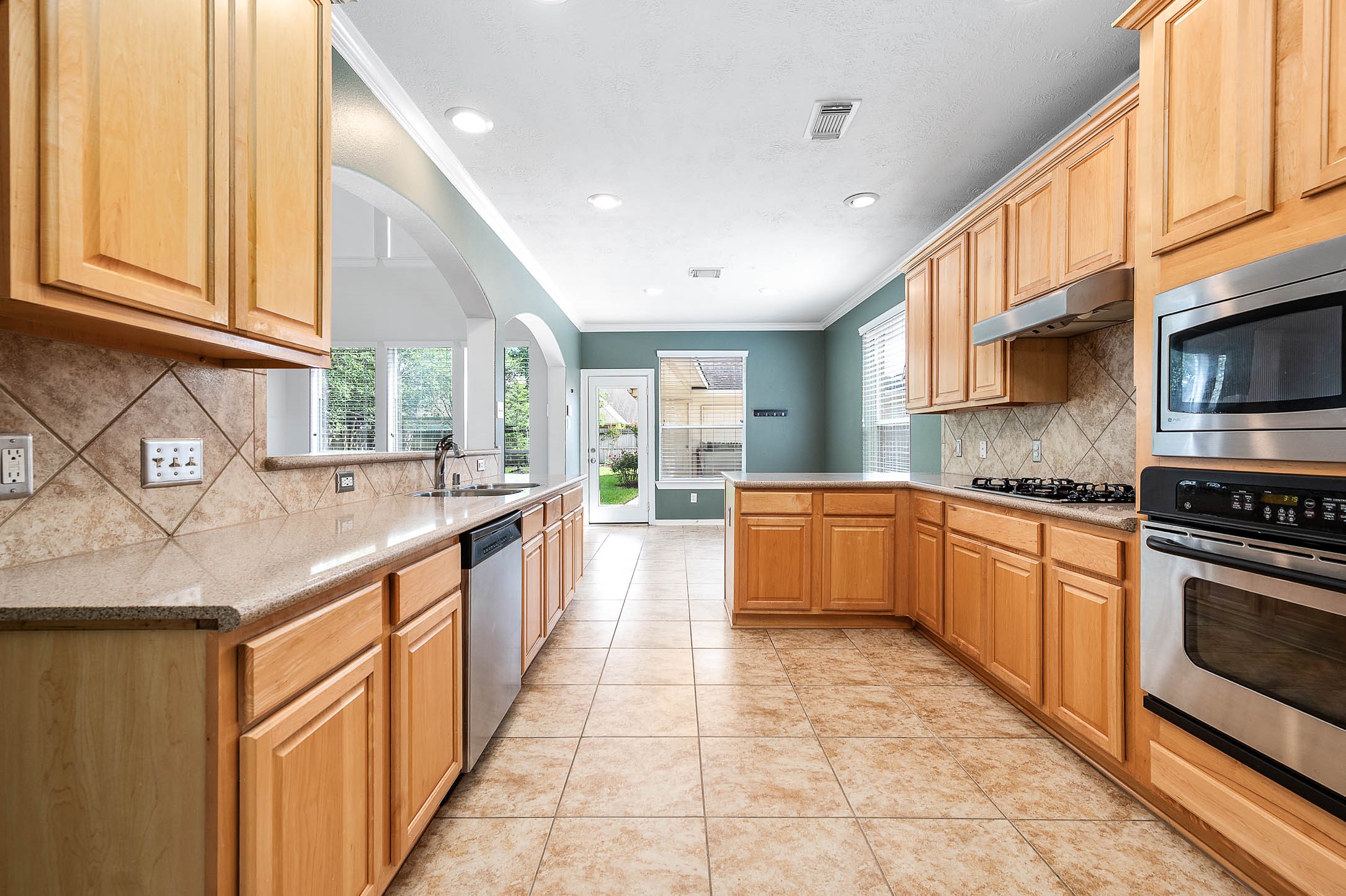6411 Greencreek Meadows Lane Spring, TX 77379 - Photo 16 of 39 a large kitchen with stainless steel appliances granite countertop a sink and cabinets