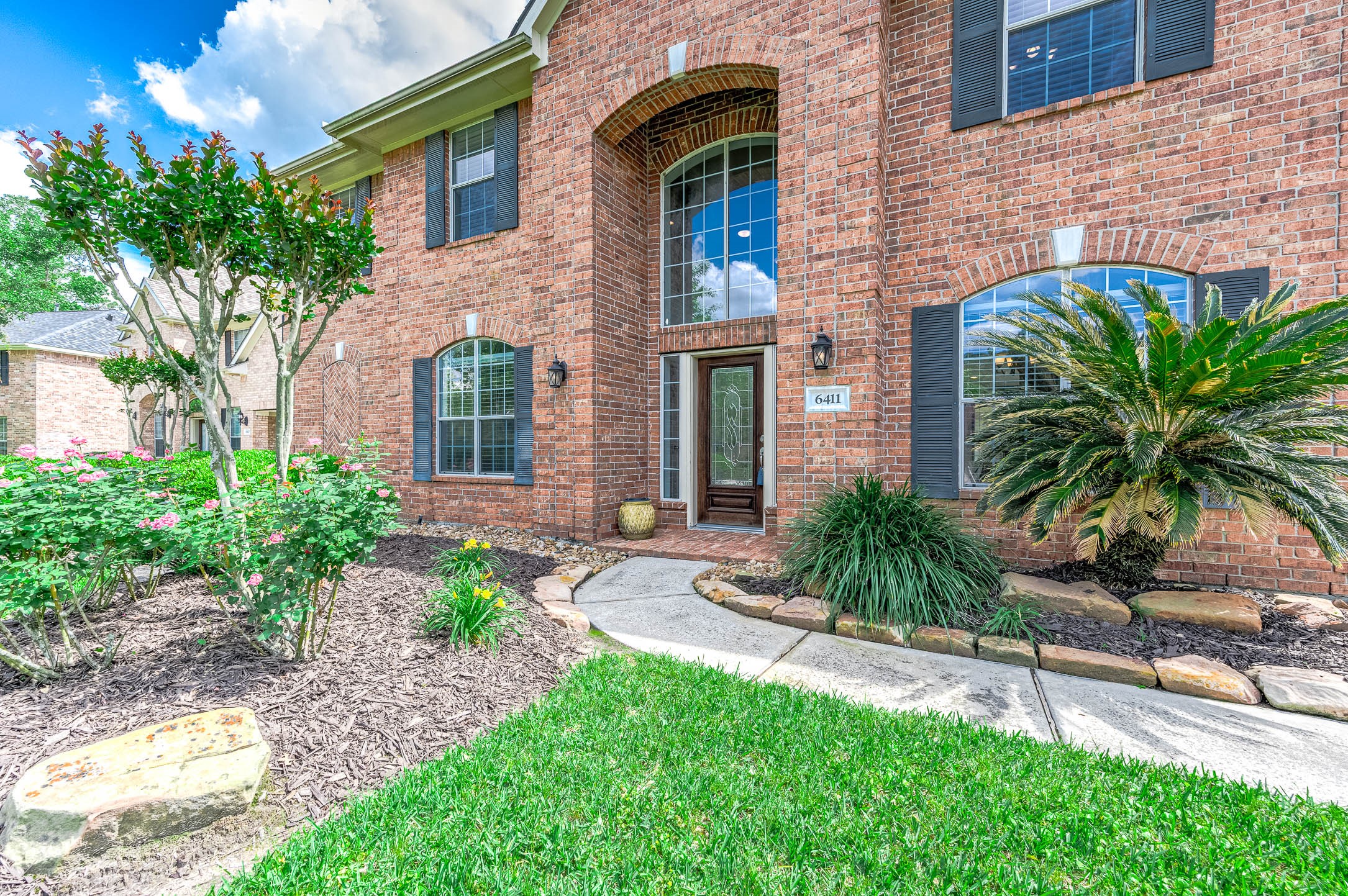 6411 Greencreek Meadows Lane Spring, TX 77379 - Photo 4 of 39 a front view of a house with a yard and potted plants