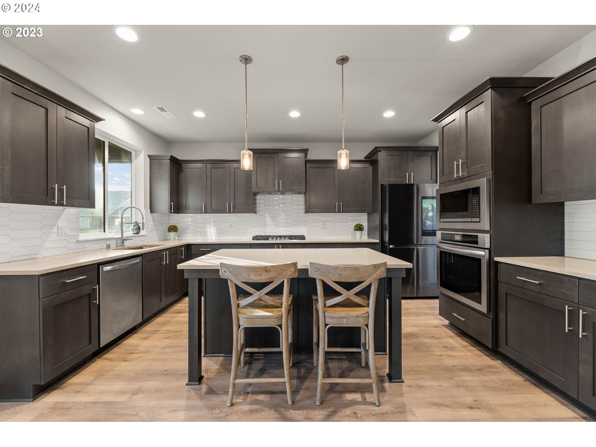 515 North 87th Court Ridgefield, WA 98642 - Photo 8 of 25 a kitchen with stainless steel appliances granite countertop a table chairs sink refrigerator and microwave
