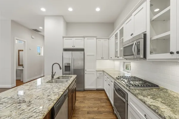a kitchen with stainless steel appliances granite countertop a sink stove and refrigerator