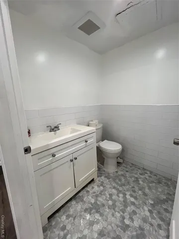 a bathroom with a sink toilet and a mirror