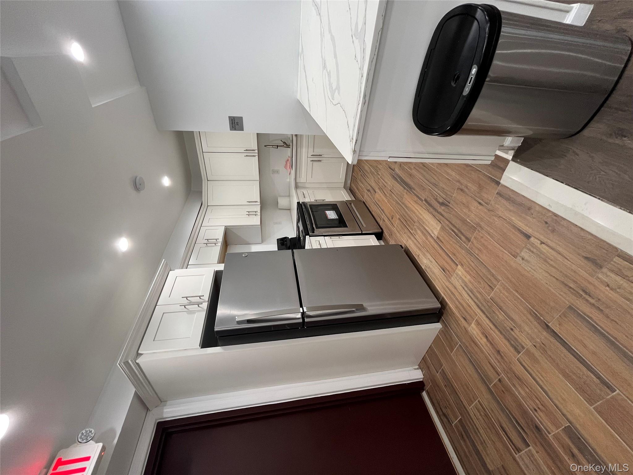 2545 Sedgwick Avenue, Unit 7B Bronx, NY 10468 - Photo 18 of 20 a kitchen with a refrigerator a stove top oven and wooden floor