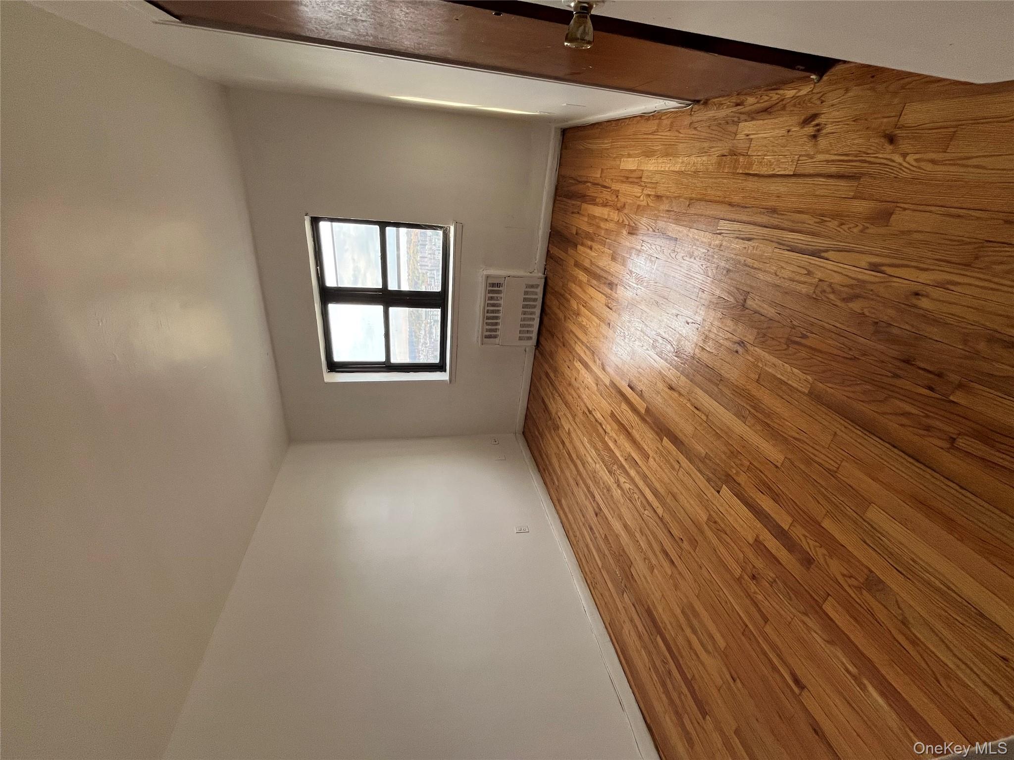 2545 Sedgwick Avenue, Unit 7B Bronx, NY 10468 - Photo 7 of 20 an empty room with wooden floor and windows