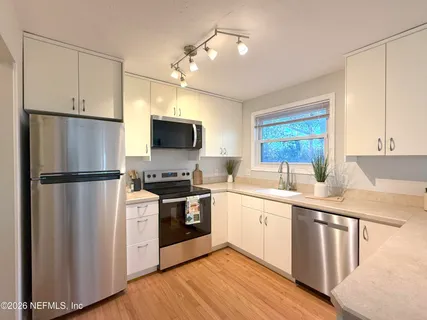 a kitchen with stainless steel appliances a refrigerator sink and microwave