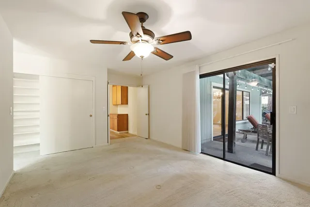 a view of a livingroom with a ceiling fan and window