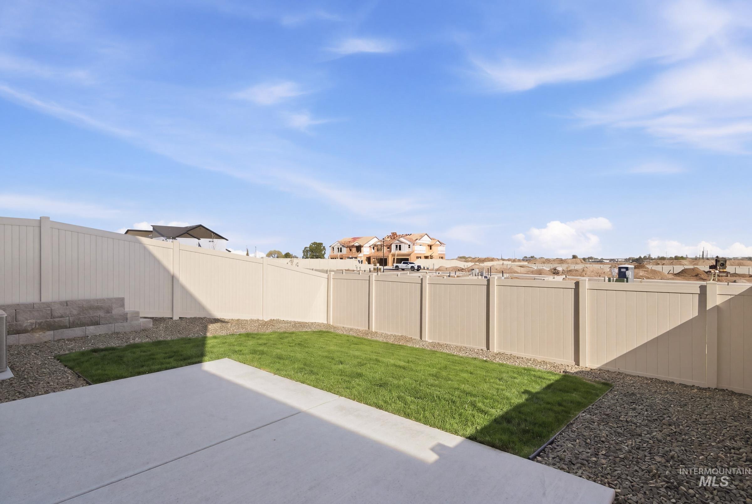 10812 Rutland Street Caldwell, ID 83605 - Photo 21 of 21 Private backyard featuring an expansive concrete patio, established lawn, gravel landscaping, and full perimeter fencing