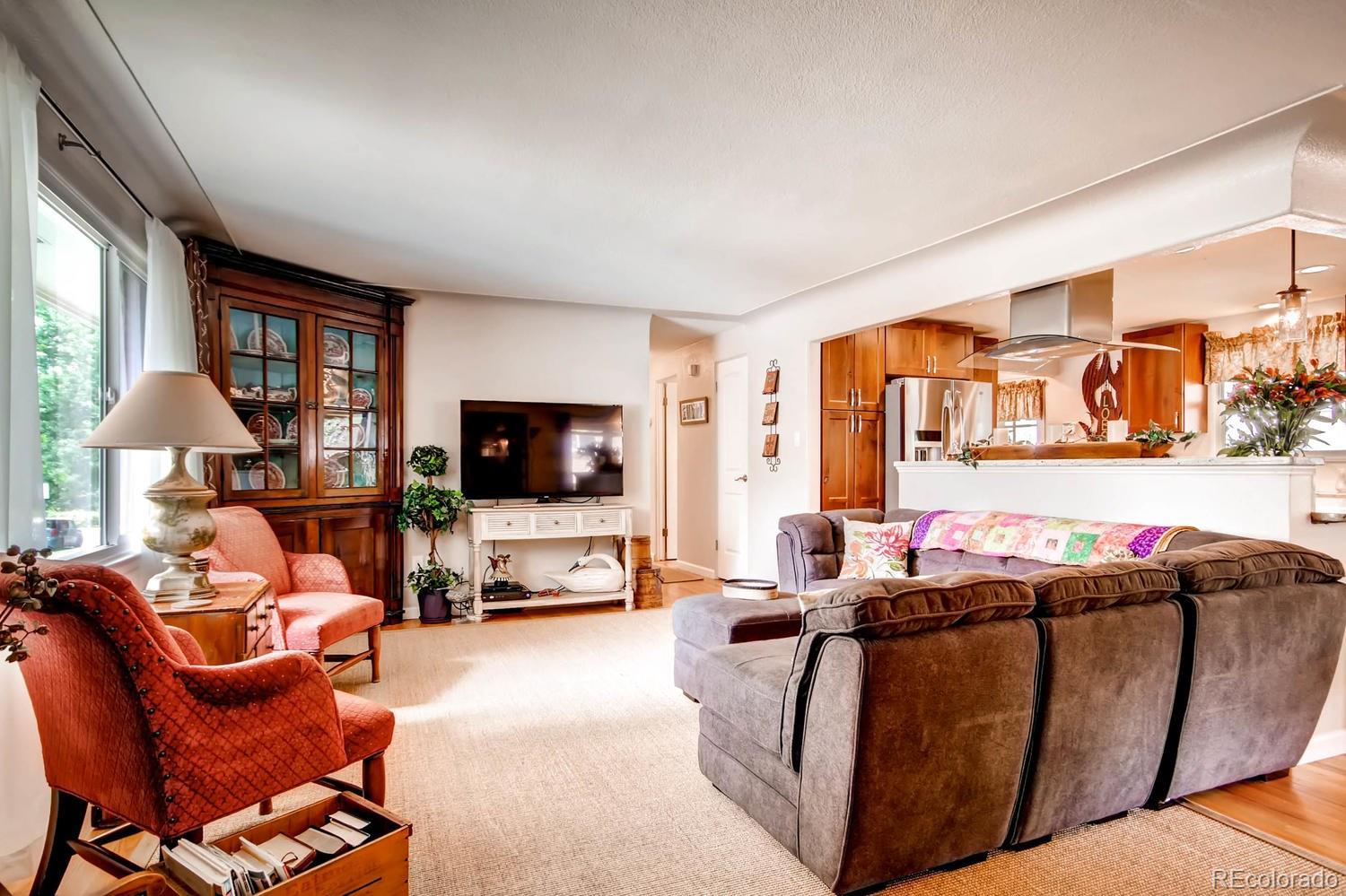 3660 Hoyt Court Wheat Ridge, CO 80033 - Photo 3 of 28 a living room with furniture a flat screen tv and a large window