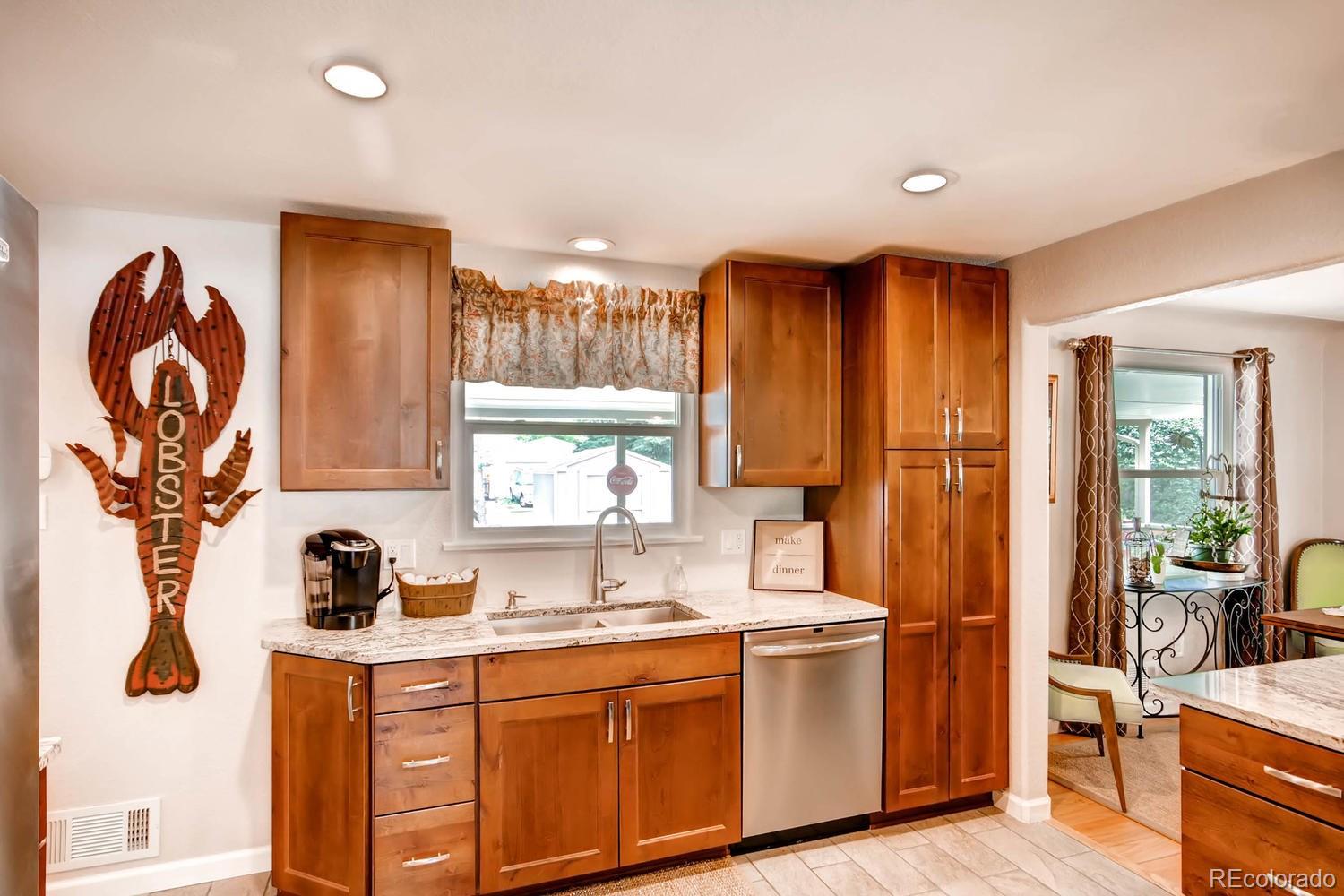 3660 Hoyt Court Wheat Ridge, CO 80033 - Photo 7 of 28 a kitchen with stainless steel appliances granite countertop a sink and a stove next to a window
