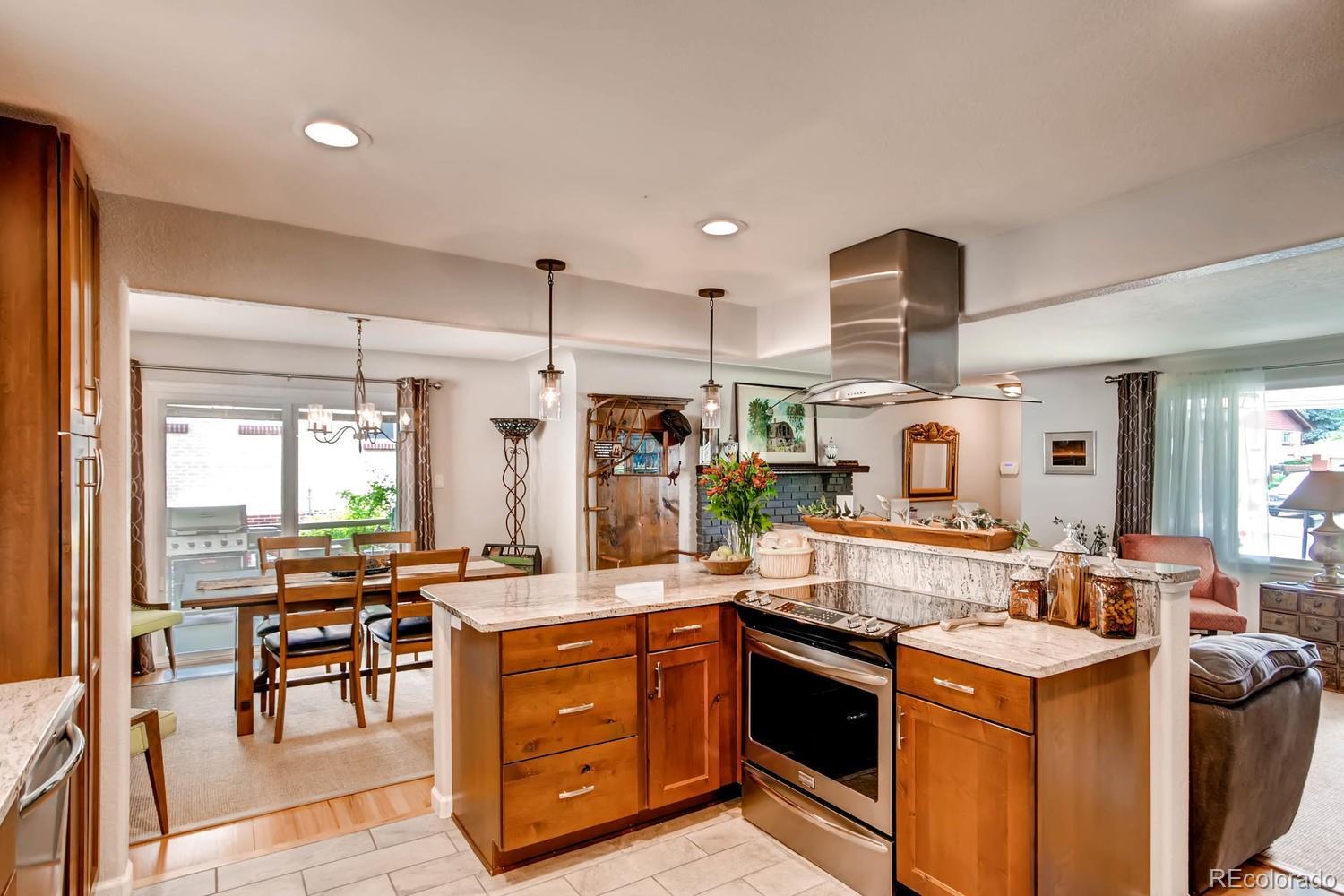 3660 Hoyt Court Wheat Ridge, CO 80033 - Photo 8 of 28 a kitchen with stainless steel appliances kitchen island granite countertop a stove and a sink