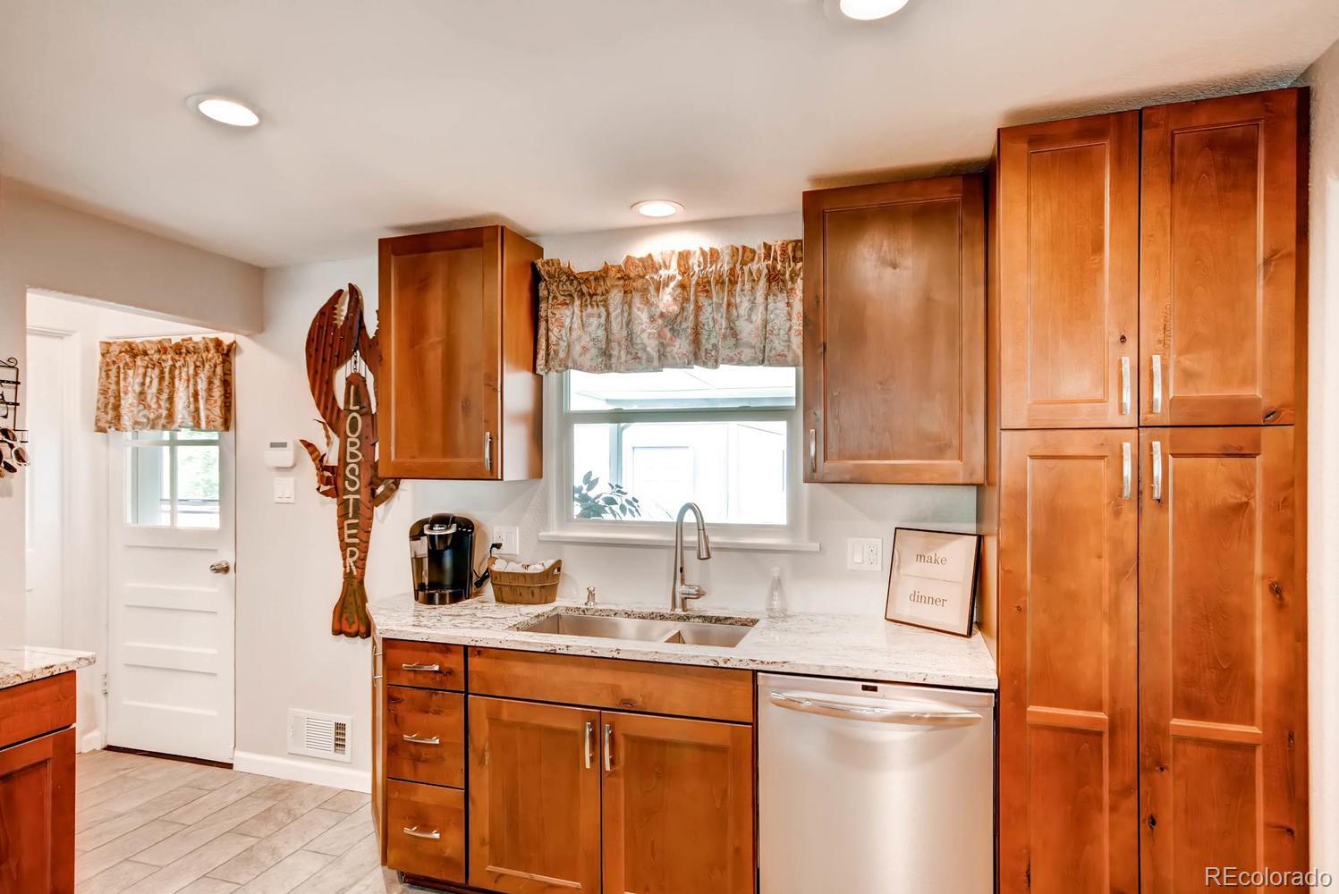 3660 Hoyt Court Wheat Ridge, CO 80033 - Photo 10 of 28 a kitchen with a refrigerator and a sink