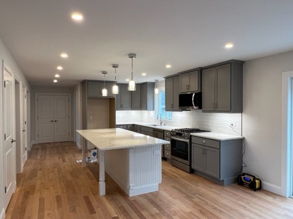 178 Andover Road Billerica, MA 01821 - Photo 8 of 39 a large kitchen with stainless steel appliances kitchen island granite countertop a stove and a sink