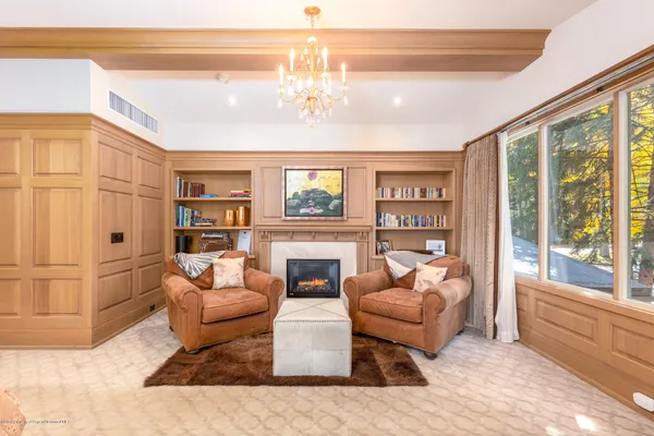 a living room with furniture a chandelier and a fireplace