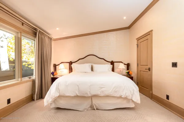 a bedroom with a bed and large window